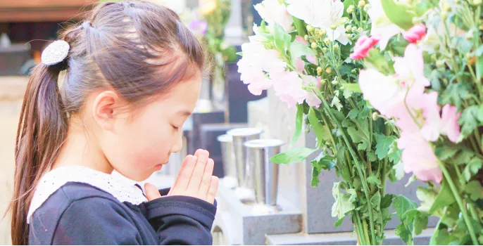 お墓参りをする女の子の写真